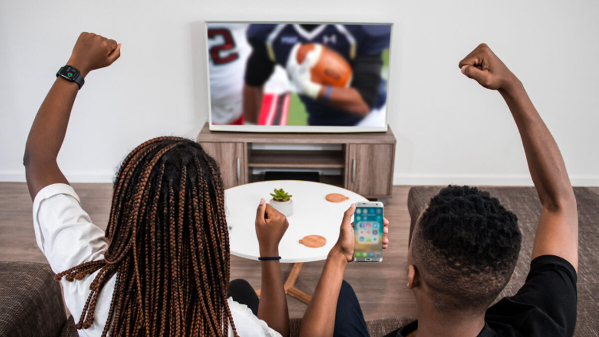 two younf boys cheer as they watch the superbowl